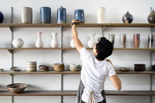 Persona agarrando vasija de una estantería