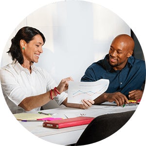 Two people reviewing a graph