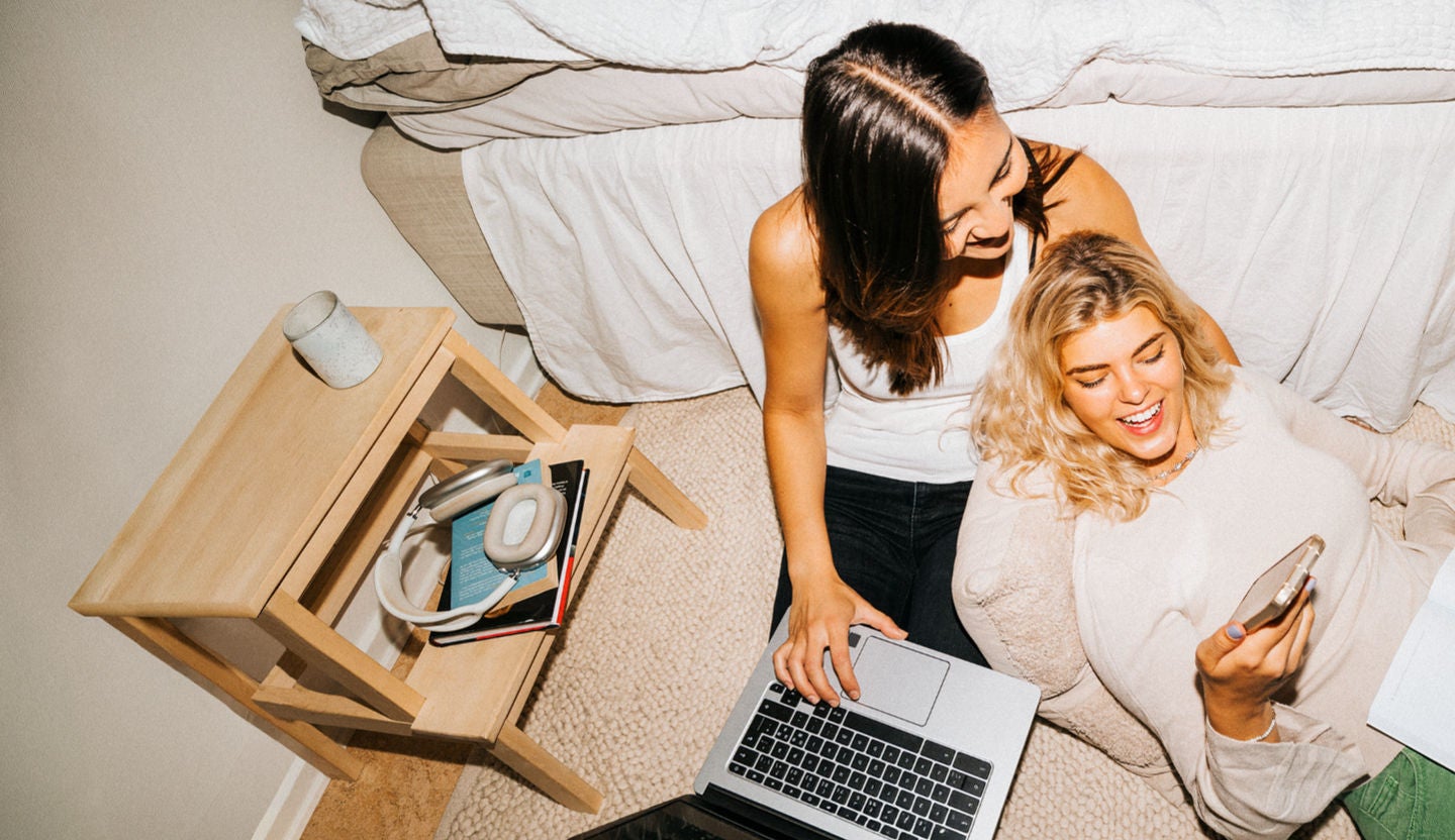 Zwei Freundinnen mit Laptop und Smartphone