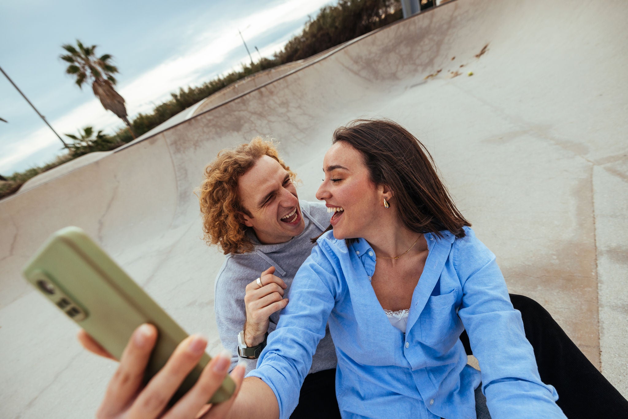 Fröhliches Paar macht Selfies im Skatepark