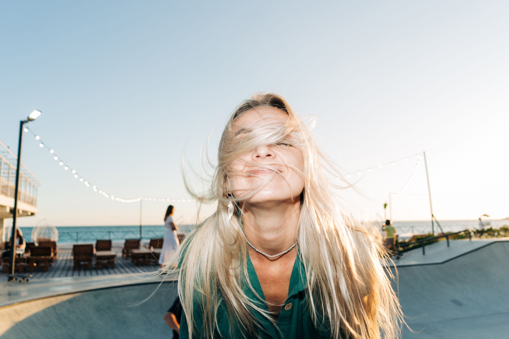 Eine junge, blonde Frau vom Wind begleitet