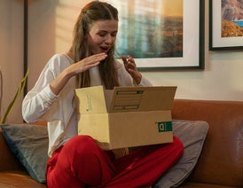 Mujer entusiasmada, abriendo una caja