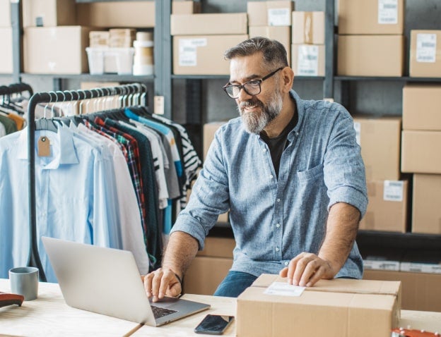 man looking at laptop in warehouse