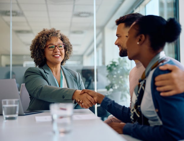Man and woman meeting with banker and shaking hands
