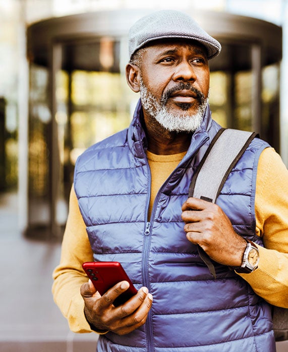 Man holding cellphone with a backpack