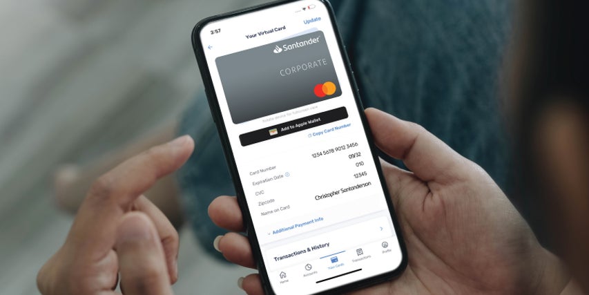 peronal holding a mobile phone with Santander credit card image on screen