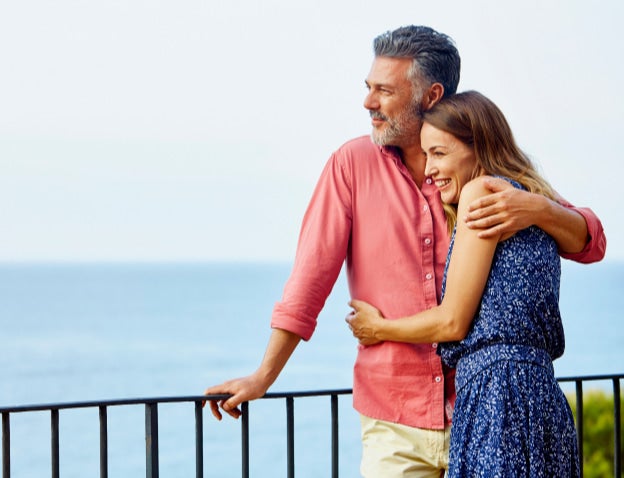 Couple embracing looking out at sea