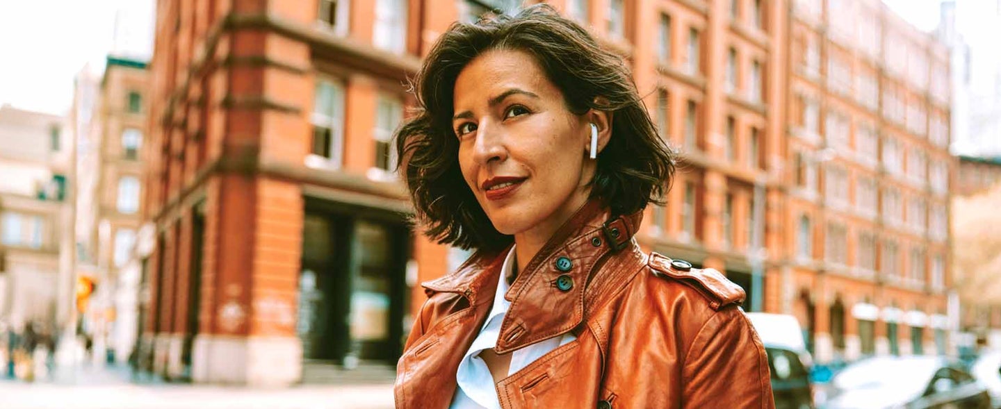 Woman in the city listening to music with earbuds