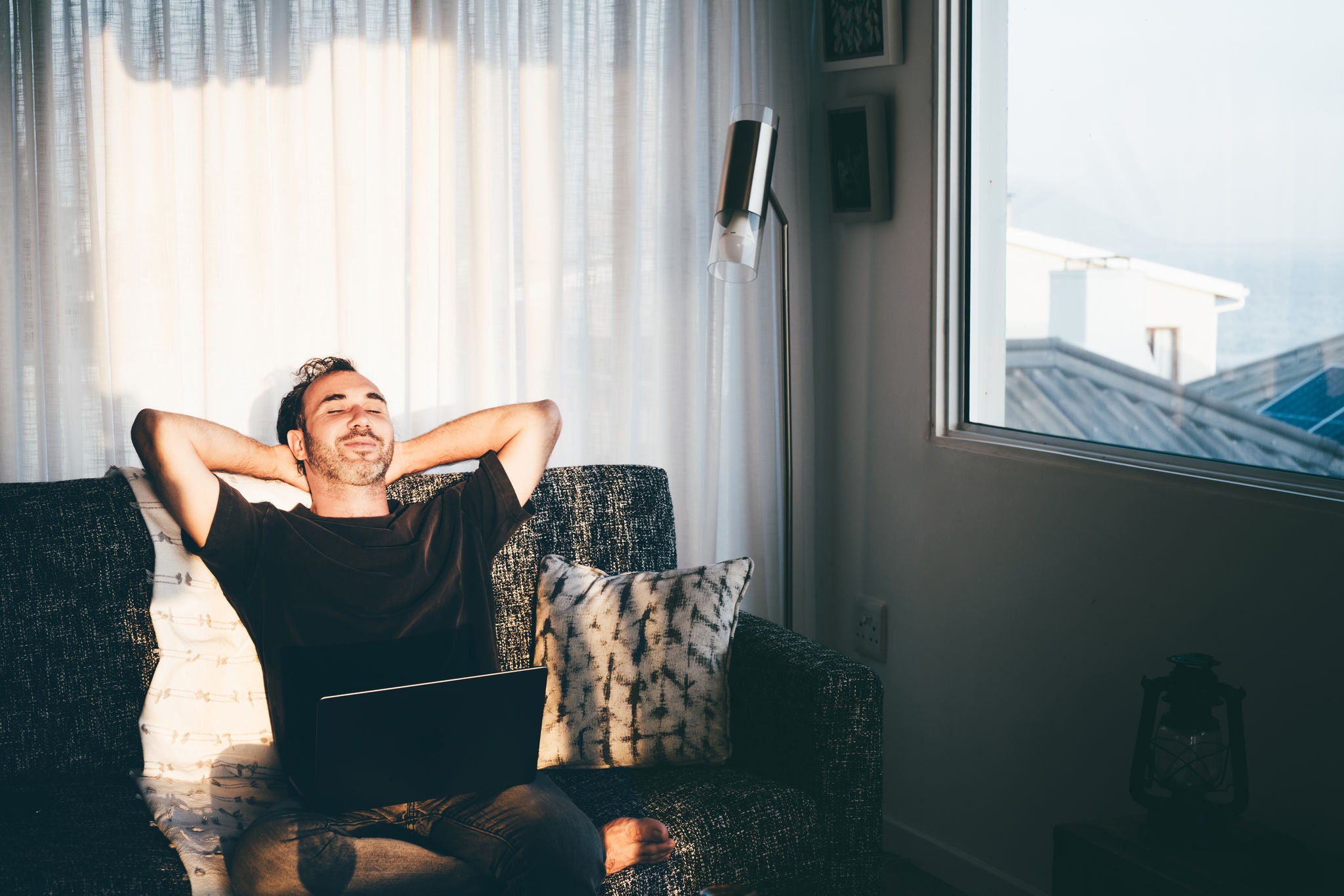 Ein Mann sitzt auf einer Couch und berechnet Umschuldung