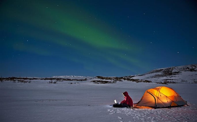 persona acampando en paisaje nevado nocturno
