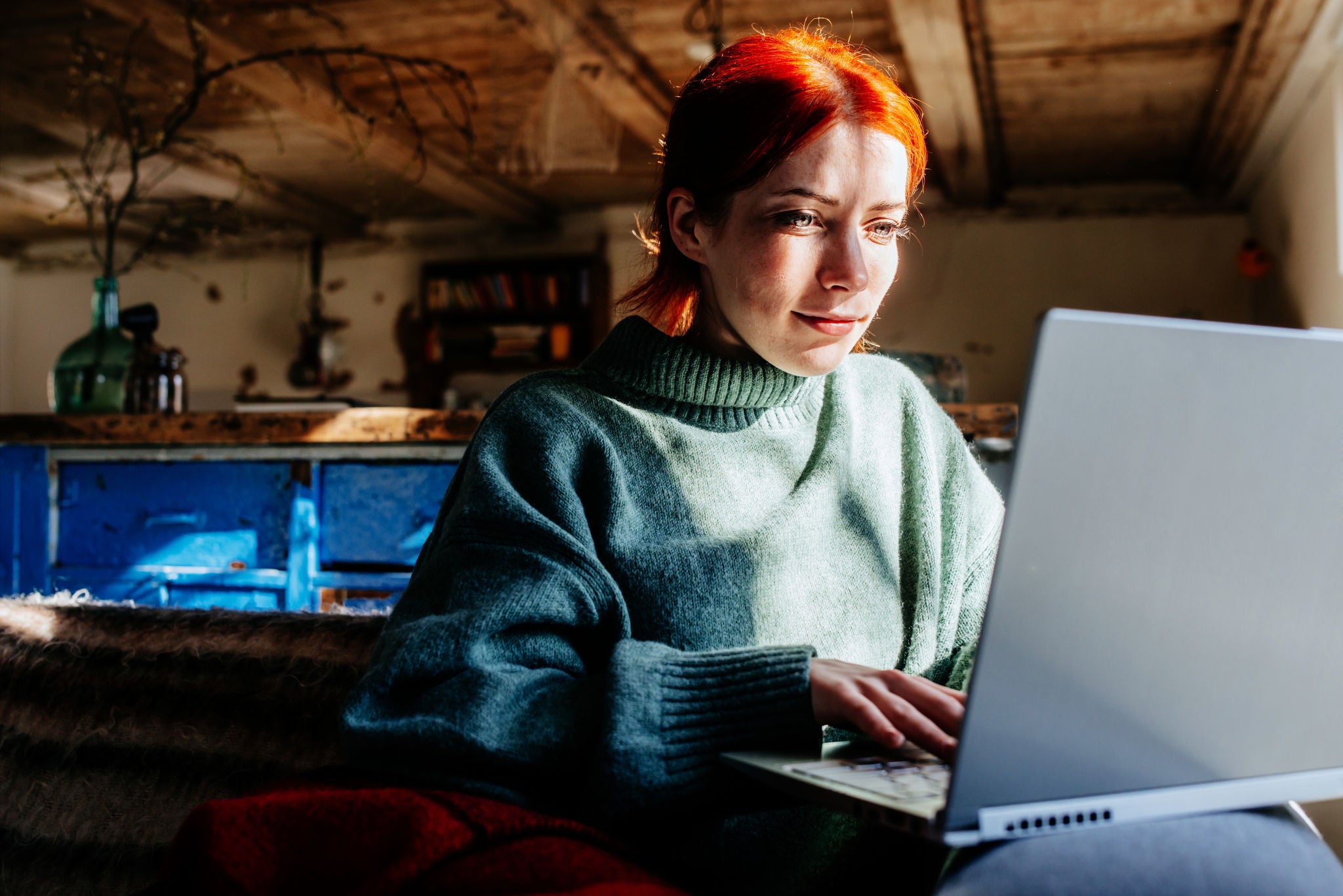 Frau sitzt am Laptop in der Sonne