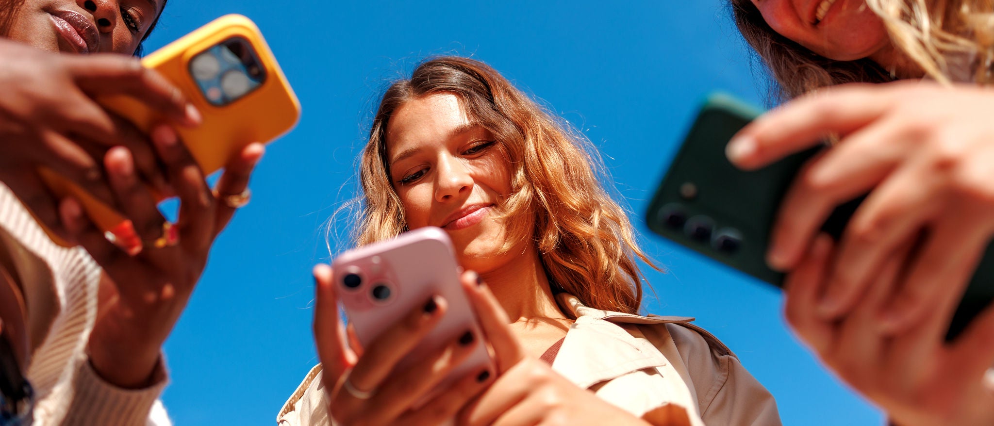 Frauen nutzen Smartphones unter freiem Himmel