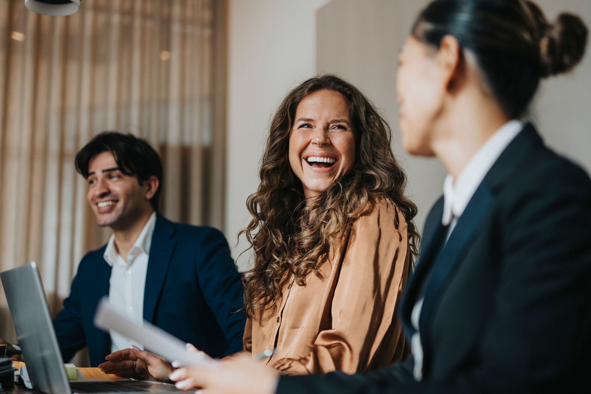 Menschen lachen zusammen im Meeting