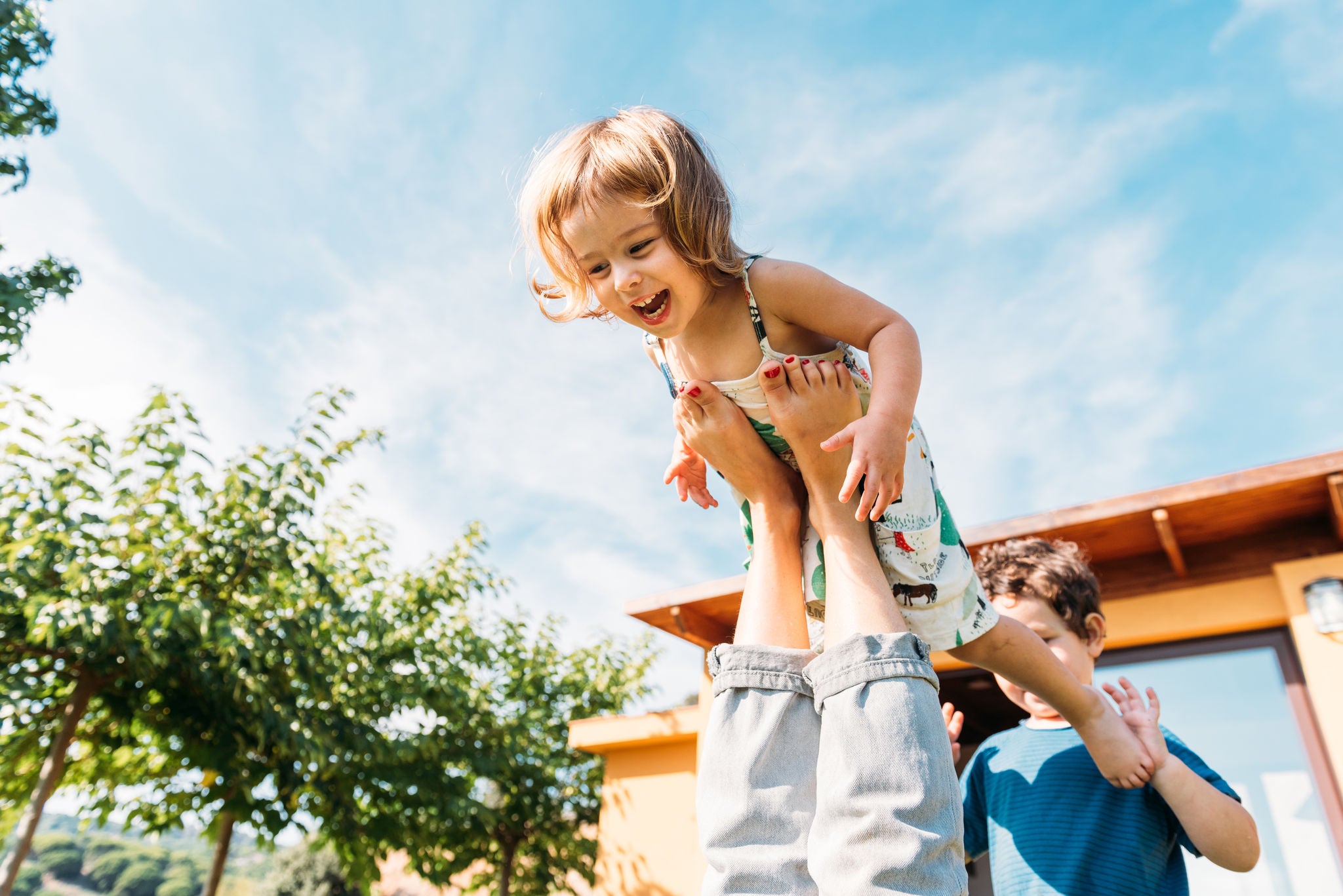 Mutter hebt ihre Tochter spielerisch in die Luft