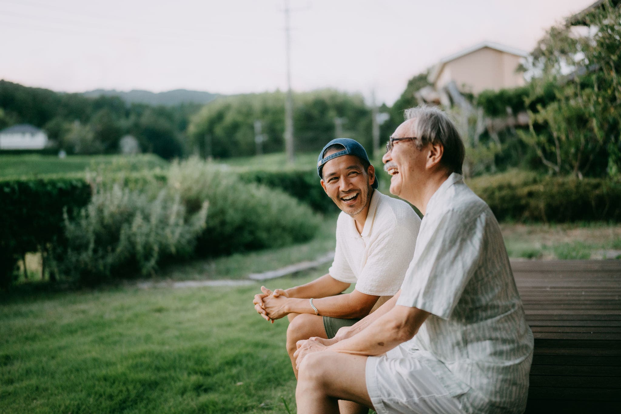 Vater und Sohn sitzen im Garten und lachen
