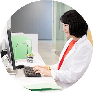Woman working on computer with lab coat
